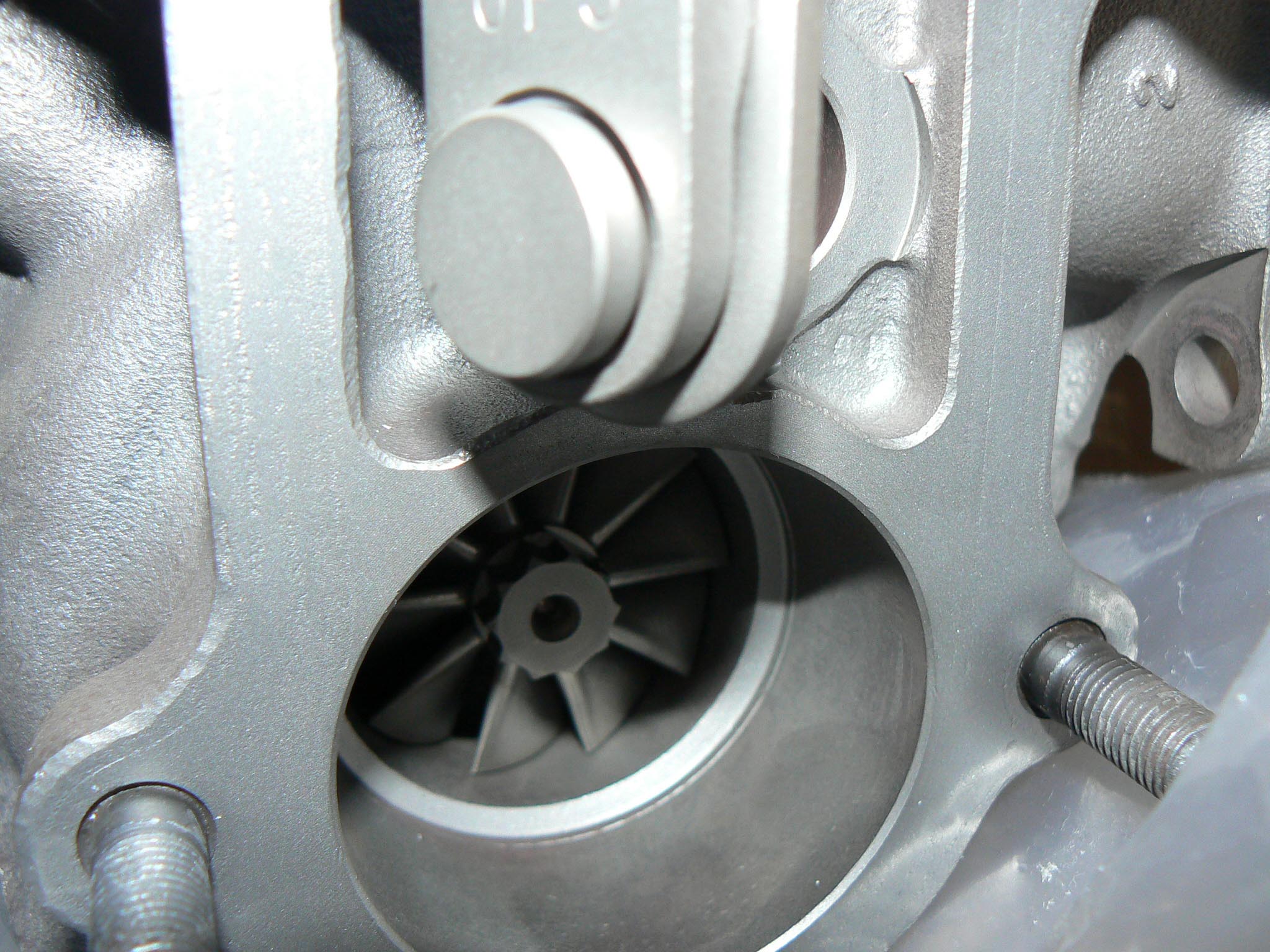 The turbocharger is an air compressor driven by an engine’s exhaust gasses. Exhaust gas exiting the engine is hot, expanding and full of energy. By routing it through a turbine, the energy in the exhaust gas is used to drive, or spin, the turbocharger. Effectively, a turbocharger sits in the engine’s exhaust stream, borrowing some of the energy from the exhaust as it exits the engine. In this picture, exhaust is forced through the turbine visible at the bottom of the turbocharger, causing it to spin rapidly, and driving the turbocharger into action. After driving the turbine, the exhaust gasses are routed through the exhaust system and out of the tailpipe.